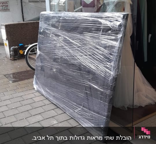 חפץ גדול עטוף בניילון מונח על המדרכה
